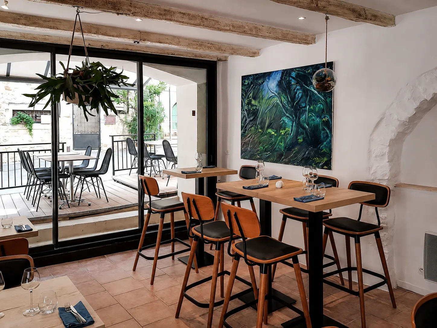 Salle ouverte sur la terrasse ombragée, toile contemporaine au mur